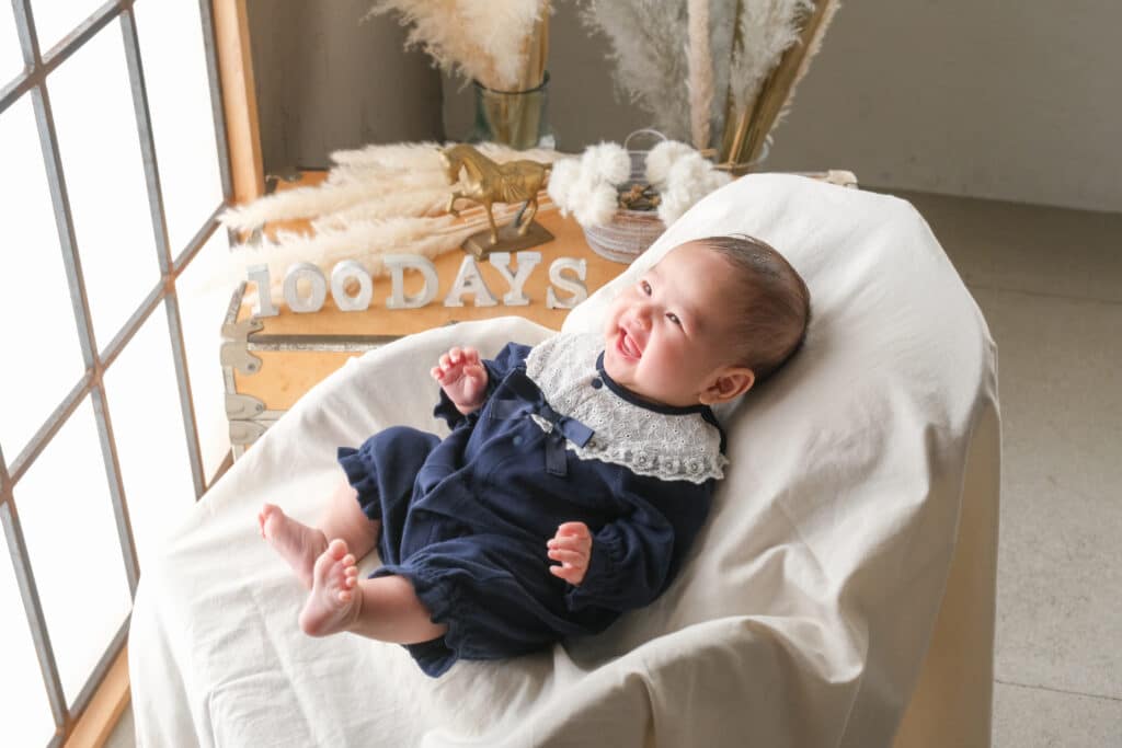 a baby lying on a white blanket