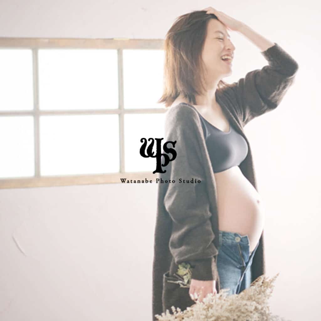 a pregnant woman smiling with her hand on her head