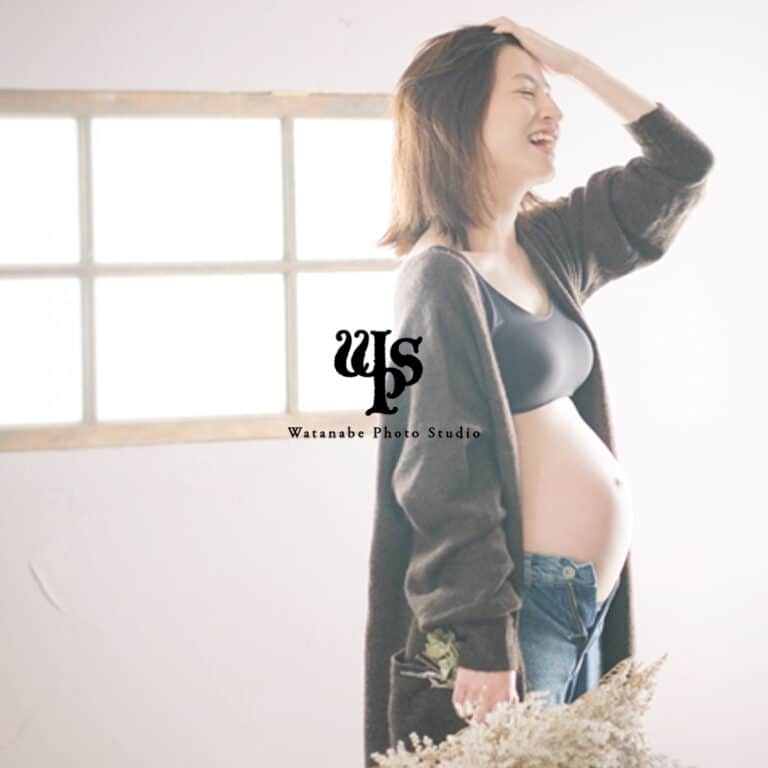 a pregnant woman smiling with her hand on her head
