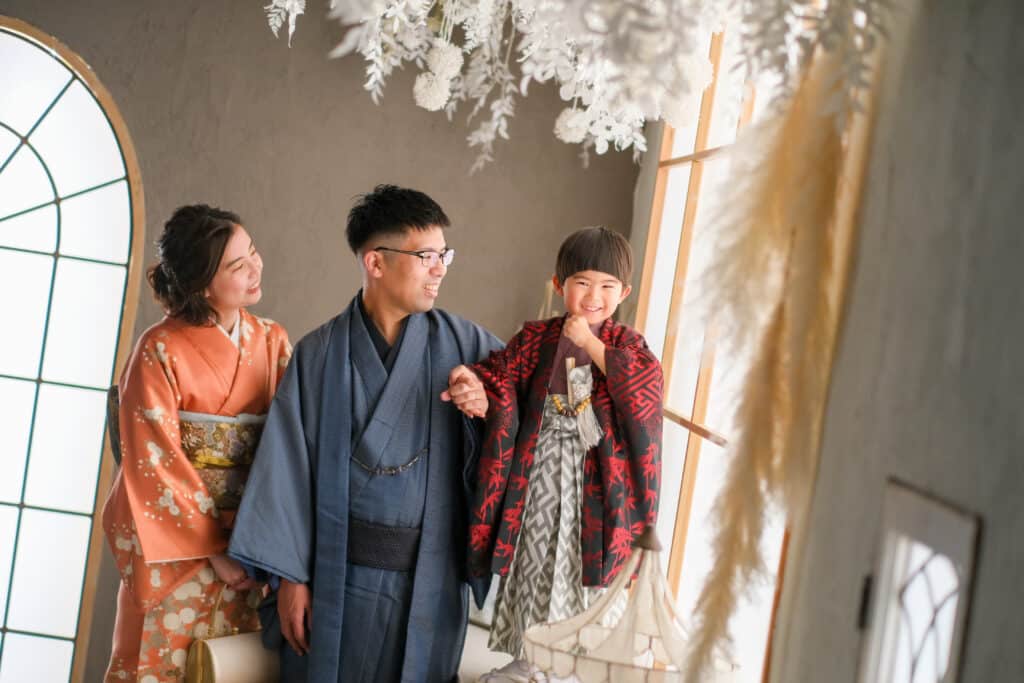a man and woman in kimonos standing next to a girl