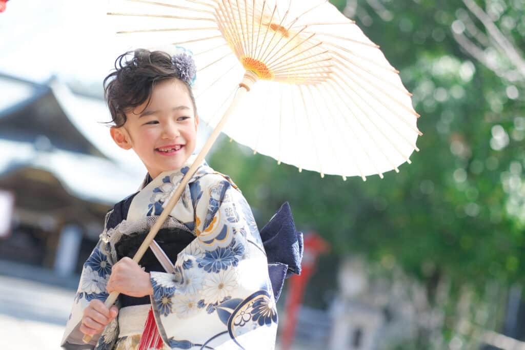 a girl in a kimono holding a paper umbrella