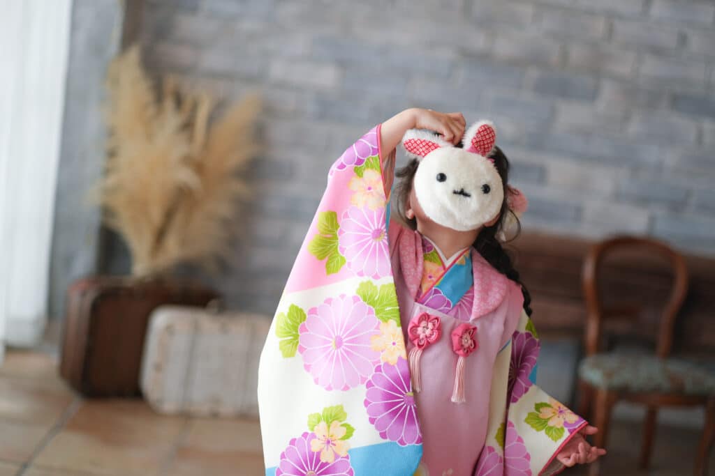 a girl wearing a mask and a blanket